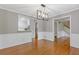 Dining area with hardwood floors and decorative lighting, showcasing seamless transition to kitchen and staircase at 425 Houze Way, Roswell, GA 30076