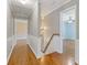 Bright hallway featuring hardwood floors and views of a bedroom and stylish lighting fixtures at 425 Houze Way, Roswell, GA 30076