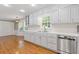 Bright, updated kitchen featuring white cabinets, stainless steel appliances, hardwood floors and a kitchen dining area at 425 Houze Way, Roswell, GA 30076