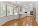 Open floorplan in kitchen with hardwood floors and white cabinets with a connecting kitchen eating area with bright windows at 425 Houze Way, Roswell, GA 30076