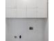 Spacious laundry room with white cabinets offering ample storage, a utility sink, and essential appliance connections at 425 Houze Way, Roswell, GA 30076