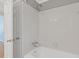 Clean white tiled shower and tub featuring chrome fixtures, and a clear glass door at 425 Houze Way, Roswell, GA 30076