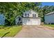Charming two-story home featuring a two-car garage and a cozy front porch entrance at 7021 New Dale Rd, Rex, GA 30273