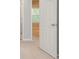 Hallway featuring carpet, a door, and a view of a window, providing natural light at 7021 New Dale Rd, Rex, GA 30273