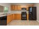 Well-equipped kitchen featuring wood cabinets, black appliances, and ample counter space at 7021 New Dale Rd, Rex, GA 30273