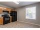 Functional kitchen with oak cabinets, black appliances, and large window providing natural light at 7021 New Dale Rd, Rex, GA 30273