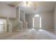 Open-concept living room with carpet, a staircase, and a front door with an arched window at 7021 New Dale Rd, Rex, GA 30273