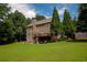 Beautiful exterior showcasing a spacious backyard with lush greenery, tall trees, and a cozy deck at 3015 Guardian Nw Walk, Kennesaw, GA 30152