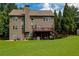 Rear view of a two-story home with a well-manicured lawn, deck, and patio offering ample space for outdoor enjoyment at 3015 Guardian Nw Walk, Kennesaw, GA 30152
