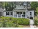 Charming white home featuring a manicured lawn, black shutters, and welcoming front porch at 502 Hascall Nw Rd, Atlanta, GA 30309
