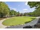 Expansive green space surrounded by mature trees and walking paths in the community at 502 Hascall Nw Rd, Atlanta, GA 30309