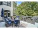 Outdoor deck featuring comfortable seating, an outdoor dining table, and views of the wooded backyard at 2295 Abbey Cove Ct, Marietta, GA 30062