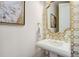Stylish powder room featuring designer gold fixtures and unique mirror at 2295 Abbey Cove Ct, Marietta, GA 30062