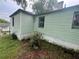 A side exterior view of a green house with windows and a concrete foundation at 4125 N Dearing Ne St, Covington, GA 30014