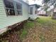 Exterior view of a home with green siding, visible windows, and overgrown landscaping at 4125 N Dearing Ne St, Covington, GA 30014