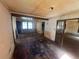 Open living room with hardwood flooring, a view of another room, and visible signs of wear at 4125 N Dearing Ne St, Covington, GA 30014