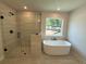 Luxurious bathroom with a glass-enclosed shower, soaking tub, and elegant fixtures at 6945 Melody Ridge Rd, Buford, GA 30518