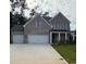 Charming two-story brick home with a three-car garage and a well-manicured lawn at 6945 Melody Ridge Rd, Buford, GA 30518