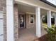View of the brick front porch showing pillars and a glass front door at 6945 Melody Ridge Rd, Buford, GA 30518