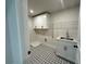 Functional laundry room with patterned floor, sink, storage and overhead cabinet at 6945 Melody Ridge Rd, Buford, GA 30518