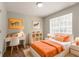 Cozy bedroom with orange-themed decor, a study desk, and ample natural light at 711 Ashley Ln, Stone Mountain, GA 30087