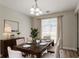 Bright dining room features modern chandelier, table set for six, elegant decor, and large window at 711 Ashley Ln, Stone Mountain, GA 30087