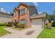 Brick two-story home showing the side with a garage, green grass, and a concrete driveway at 711 Ashley Ln, Stone Mountain, GA 30087
