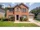 Charming two-story brick home with well-maintained landscaping, complemented by green grass and mature trees at 711 Ashley Ln, Stone Mountain, GA 30087