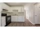 Bright kitchen with white cabinets, black appliances, laminate floors, and a modern aesthetic at 711 Ashley Ln, Stone Mountain, GA 30087