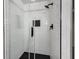 Glass enclosed shower with black hardware and subway tile surround and black hexagon tile shower floor at 2550 Laurel Ridge Dr, Decatur, GA 30033
