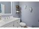Well-lit powder room showcasing a modern sink vanity, toilet, and decorative wall art at 428 Gold Xing, Canton, GA 30114