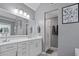 Bright bathroom featuring dual vanities, a large mirror, a glass-enclosed shower, and sleek fixtures at 428 Gold Xing, Canton, GA 30114