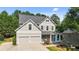 Charming two-story home featuring a gray exterior, a two-car garage, and a welcoming front porch at 428 Gold Xing, Canton, GA 30114