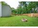 Spacious backyard with lush green grass, mature trees, and a charming fire pit area at 963 Turner Se Dr, Smyrna, GA 30080