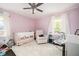 Bedroom with crib, rocking chair, and white rug bathed in natural light from the bright windows at 963 Turner Se Dr, Smyrna, GA 30080