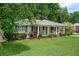 Charming single-story home featuring a well-manicured lawn and inviting front porch with a cheerful blue door at 963 Turner Se Dr, Smyrna, GA 30080