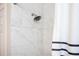 Close up of the shower with marble tile and blue striped shower curtain at 963 Turner Se Dr, Smyrna, GA 30080