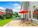 Backyard patio with stone pavers and outdoor furniture with green grass, landscaping and a partial view of the house at 560 Edgehill Pl, Johns Creek, GA 30022