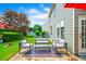 Backyard patio with stone pavers and outdoor furniture with green grass, landscaping and a partial view of the house at 560 Edgehill Pl, Johns Creek, GA 30022