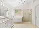 Elegant bathroom featuring a modern bathtub, glass-enclosed shower, a dual sink vanity with stone countertops at 560 Edgehill Pl, Johns Creek, GA 30022