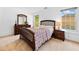 This cozy bedroom features a wooden bed frame, dresser, bedside table and sunlight streaming in from the windows at 560 Edgehill Pl, Johns Creek, GA 30022