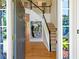 View of foyer with an open doorway, staircase, and decorative wall art at 560 Edgehill Pl, Johns Creek, GA 30022
