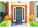 Inviting front entrance featuring brick accents, a stylish gray door, and decorative potted plants at 560 Edgehill Pl, Johns Creek, GA 30022