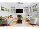 Bright living room with a fireplace, built-in shelving, modern decor, and large windows at 560 Edgehill Pl, Johns Creek, GA 30022
