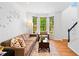 Inviting living room featuring a cozy couch, natural light from bay windows, and stylish decor at 560 Edgehill Pl, Johns Creek, GA 30022