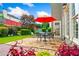 Beautiful stone patio with outdoor seating, red umbrella, and lush landscaping at 560 Edgehill Pl, Johns Creek, GA 30022