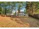 Large backyard showcasing a firepit area, privacy fence, and mature trees offering shade and seclusion at 5735 Lake Windsor Pkwy, Buford, GA 30518