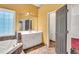 Bright bathroom featuring a vanity, tub, and an open doorway leading to another room at 5735 Lake Windsor Pkwy, Buford, GA 30518
