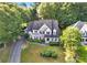 Charming two-story home with a brick facade, well-manicured lawn, mature trees, and a welcoming front porch at 5735 Lake Windsor Pkwy, Buford, GA 30518