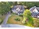 Charming two-story home with a brick facade, well-manicured lawn, mature trees, and a welcoming front porch at 5735 Lake Windsor Pkwy, Buford, GA 30518